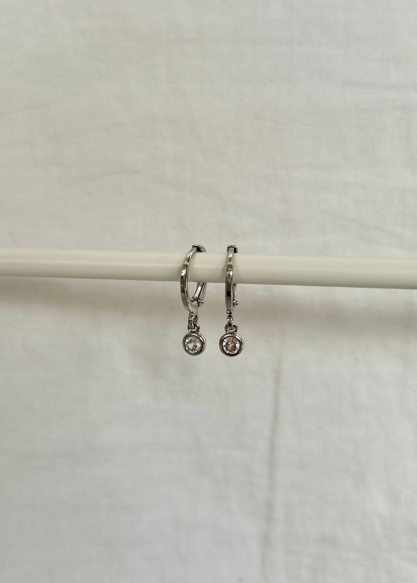 TINY DROP HUGGIE EARRINGS IN PLATINUM