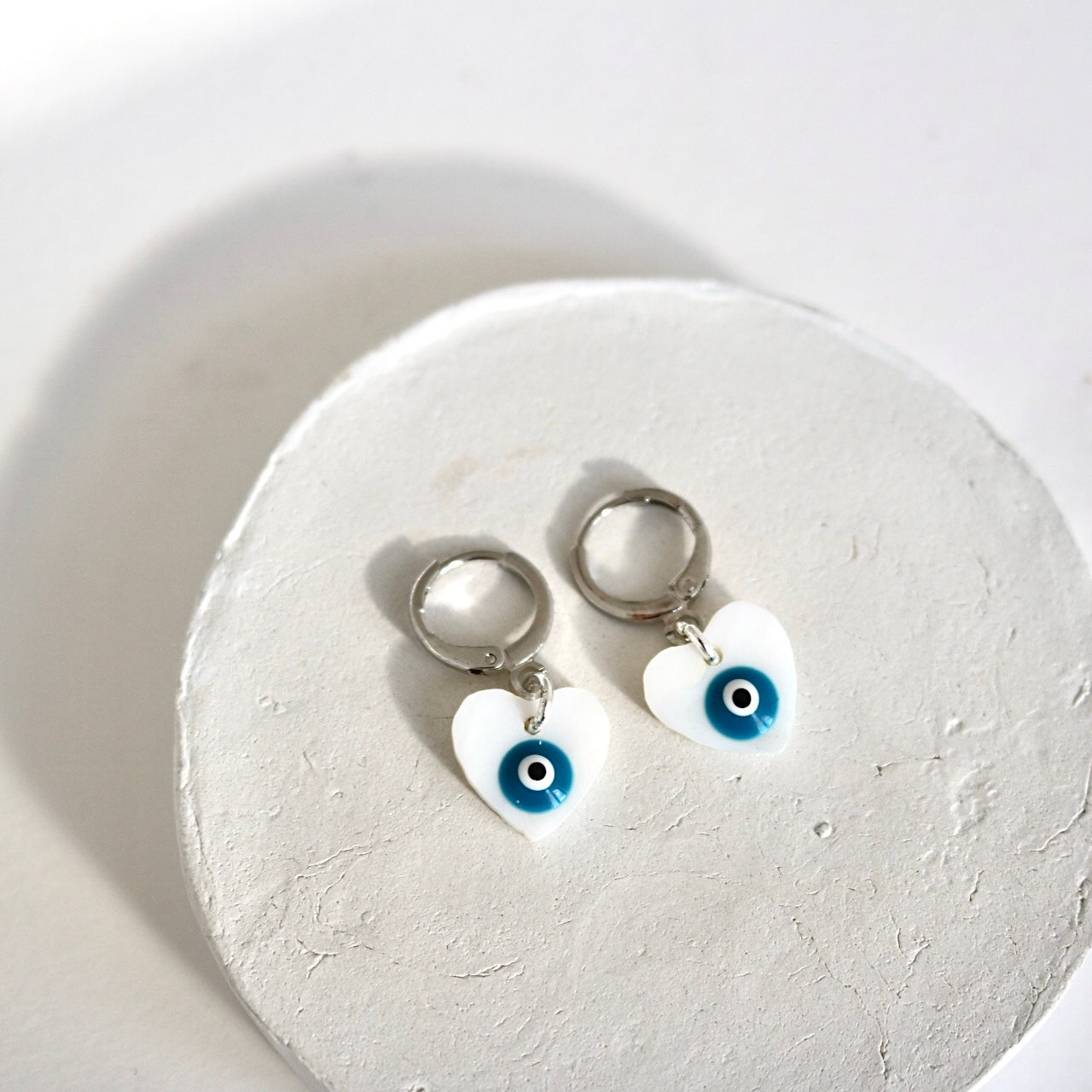 EVIL EYE HEART FRESHWATER SHELL HUGGIE EARRINGS IN PLATINUM