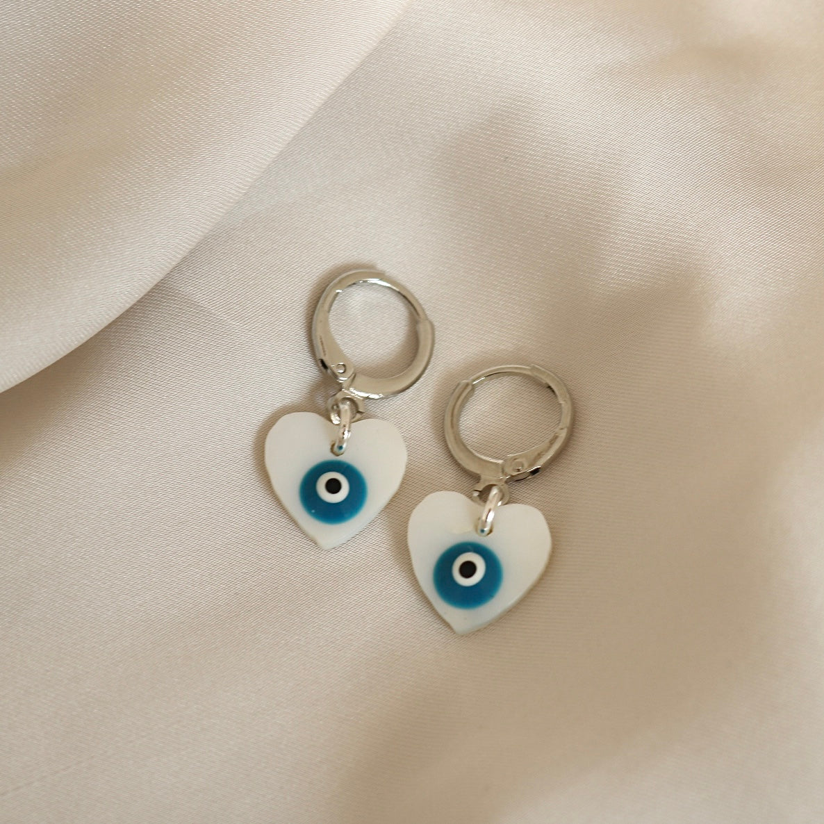 EVIL EYE HEART FRESHWATER SHELL HUGGIE EARRINGS IN PLATINUM